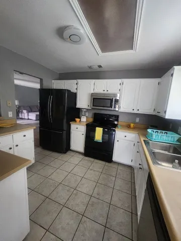 a kitchen with stainless steel appliances granite countertop a refrigerator and a stove