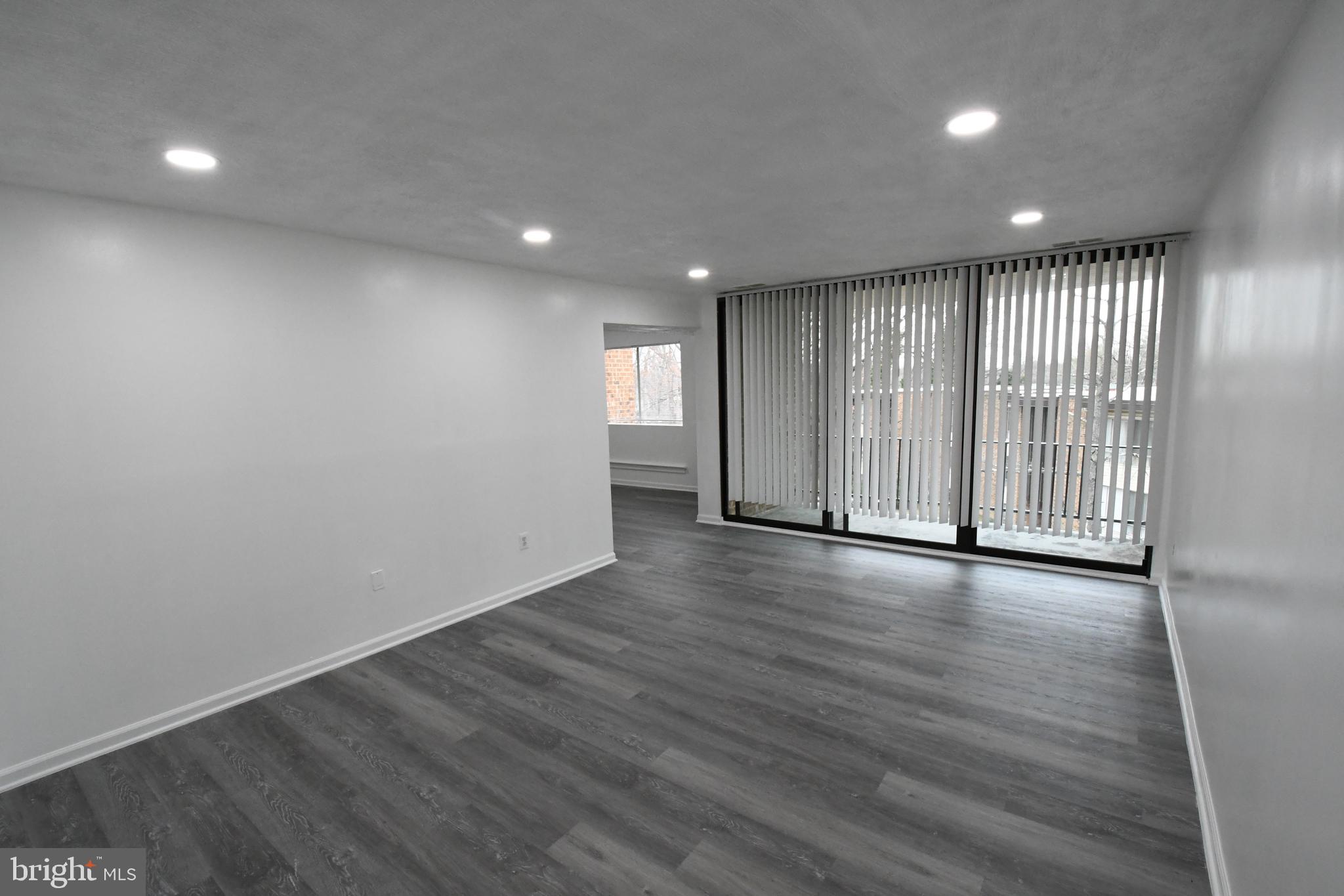 8459 Greenbelt Road, Unit 201 Greenbelt, MD 20770 - Photo 1 of 15 an empty room with wooden floor and windows