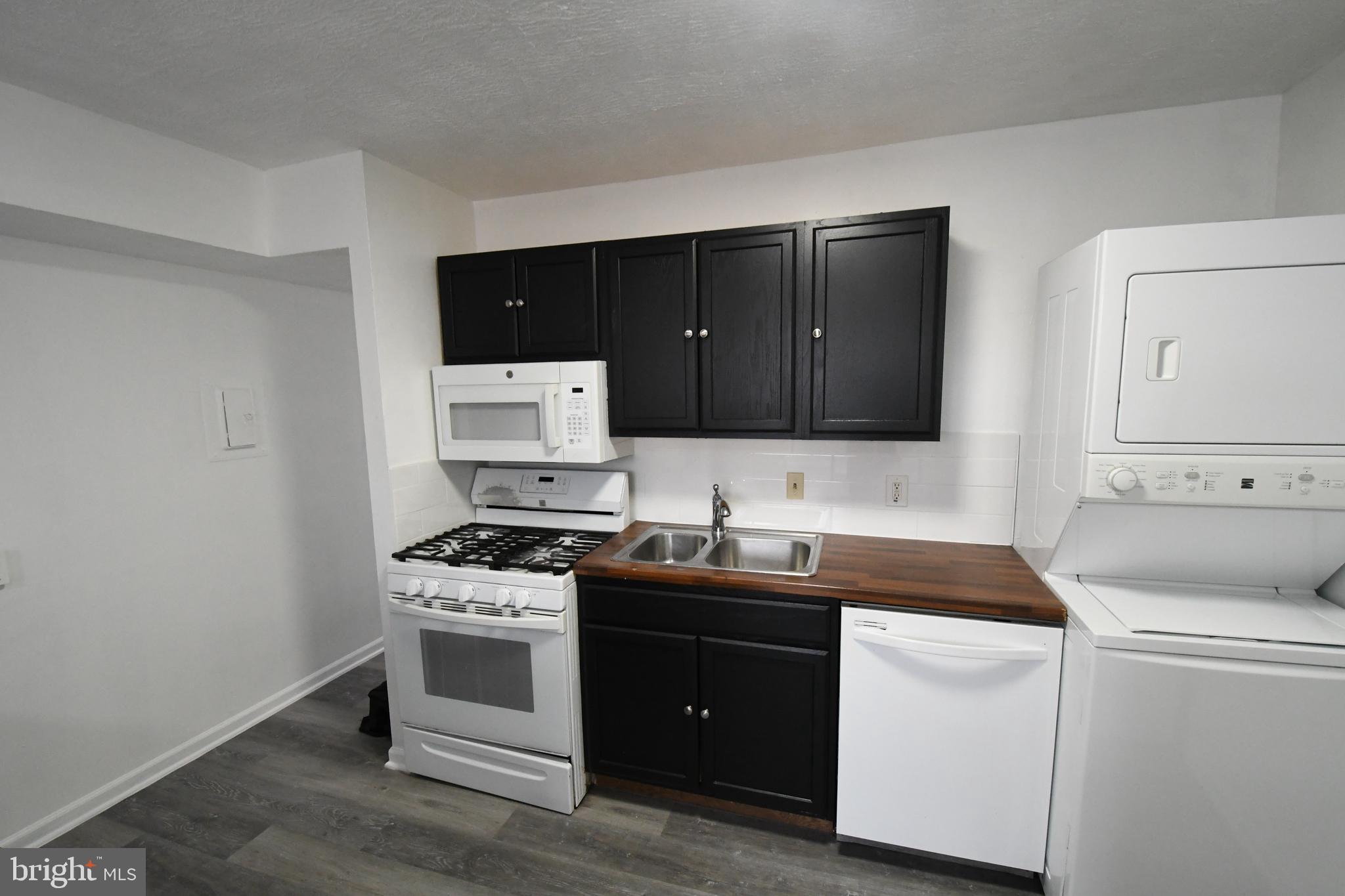 8459 Greenbelt Road, Unit 201 Greenbelt, MD 20770 - Photo 14 of 15 a kitchen with a sink stove and cabinets