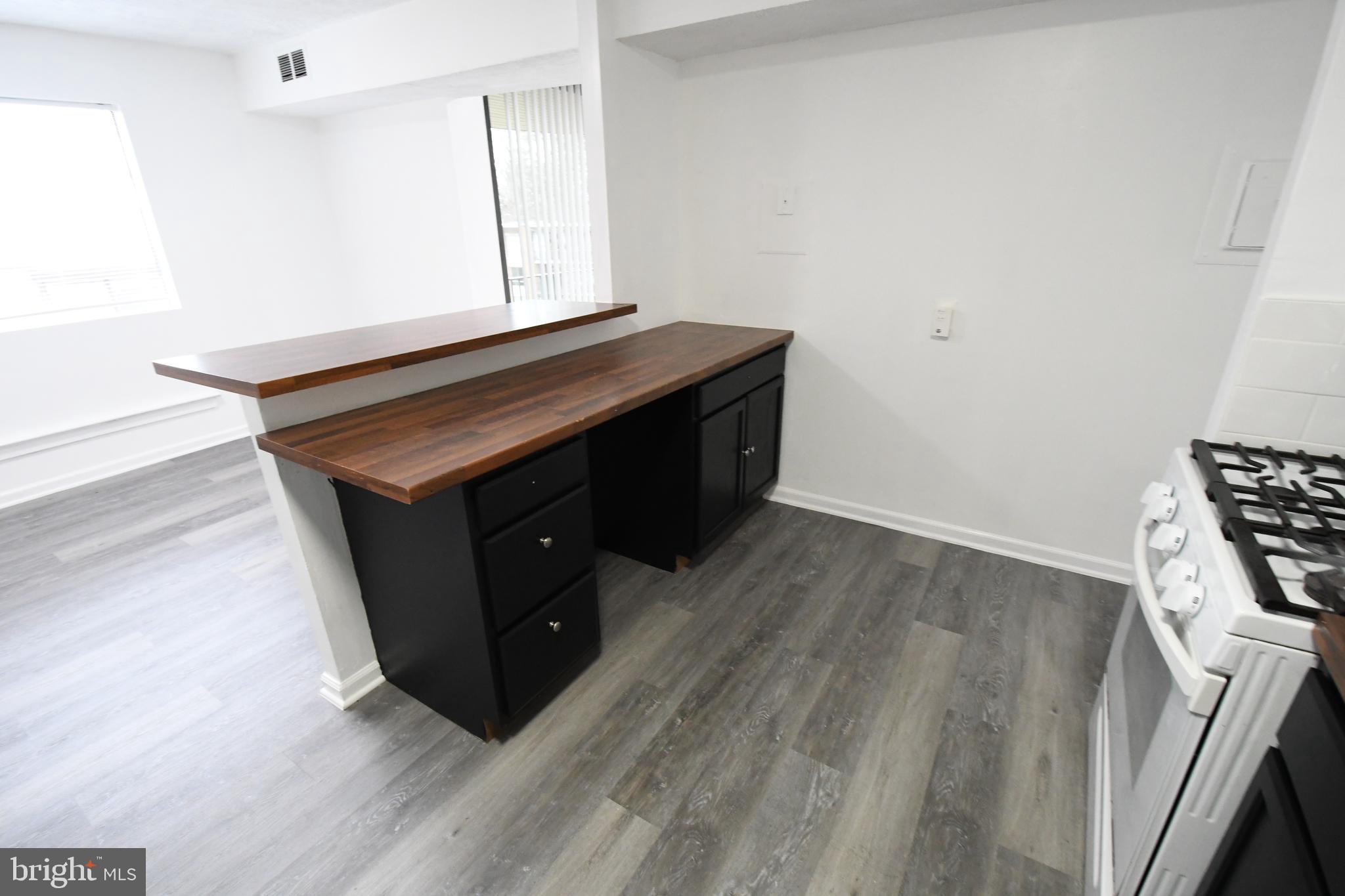 8459 Greenbelt Road, Unit 201 Greenbelt, MD 20770 - Photo 15 of 15 a room with wooden floor and white walls