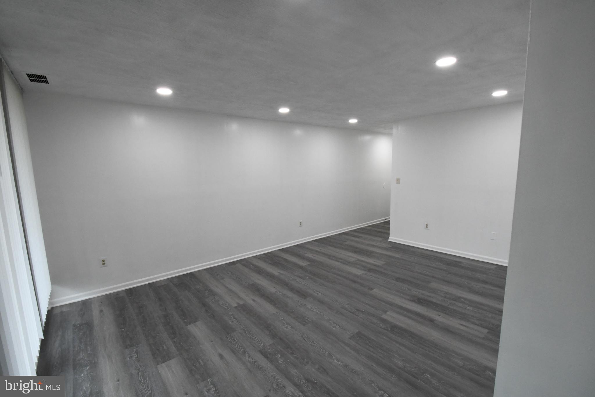 8459 Greenbelt Road, Unit 201 Greenbelt, MD 20770 - Photo 3 of 15 an empty room with wooden floor and windows
