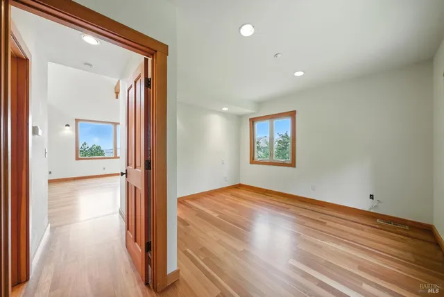 a view of a hallway with wooden floor and staircase