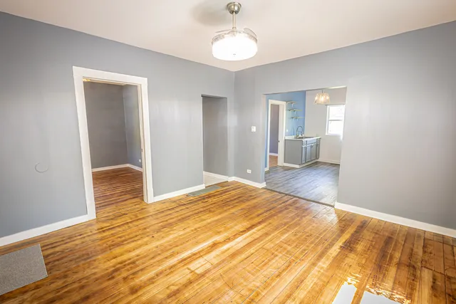 a view of a room with wooden floor and ceiling fan