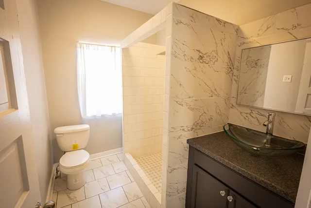 a bathroom with a sink a toilet and a mirror