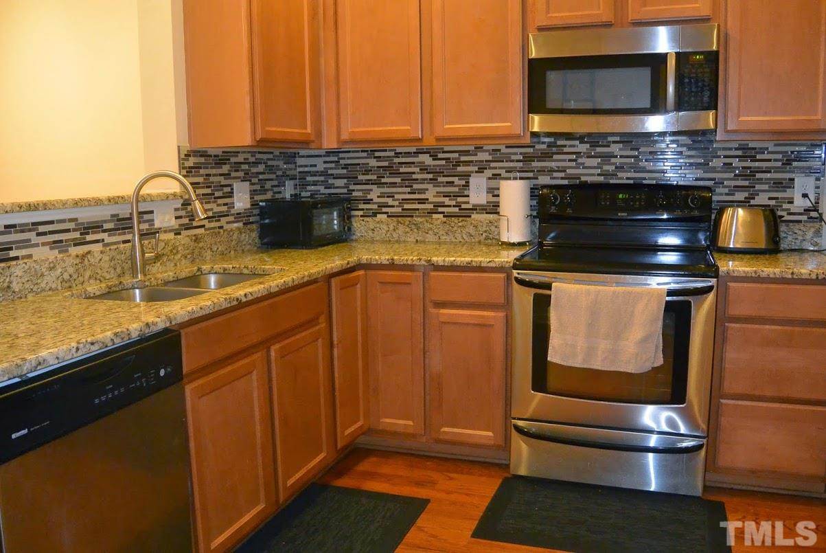 1029 Summerhouse Road Cary, NC 27519 - Photo 6 of 17 a kitchen with stainless steel appliances and cabinets