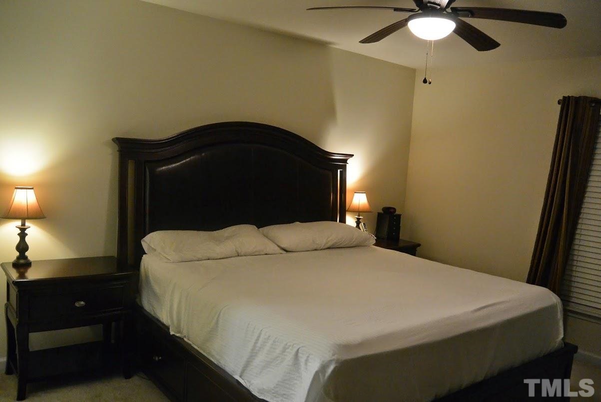 1029 Summerhouse Road Cary, NC 27519 - Photo 8 of 17 a bedroom with a bed and a chandelier