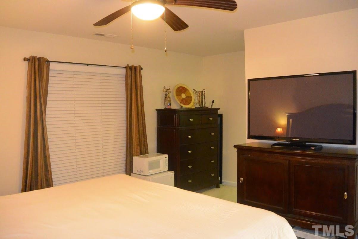 1029 Summerhouse Road Cary, NC 27519 - Photo 9 of 17 a bedroom with a bed and a flat screen tv