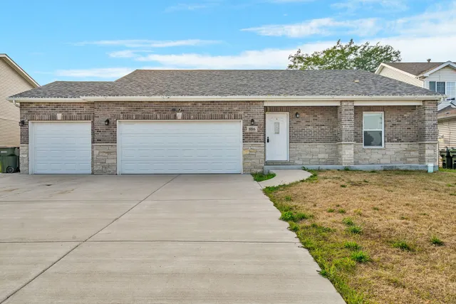 a front view of a house with a yard and garage