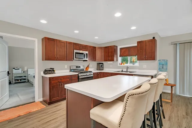a kitchen with stainless steel appliances granite countertop a refrigerator a stove top oven a sink and dishwasher