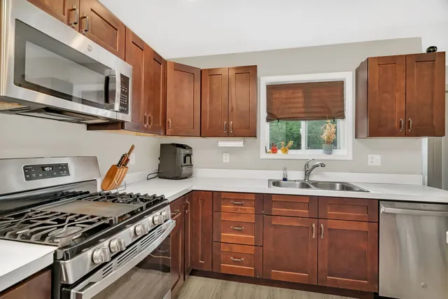 a kitchen with stainless steel appliances granite countertop a stove a sink dishwasher and a microwave