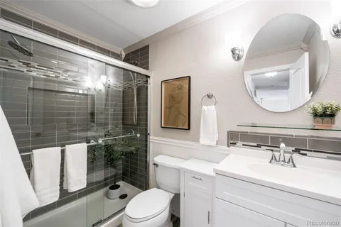 a bathroom with a sink vanity mirror and toilet