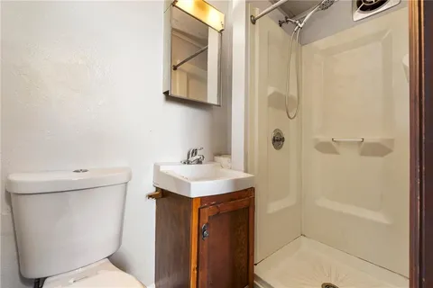 a bathroom with a sink a toilet and shower