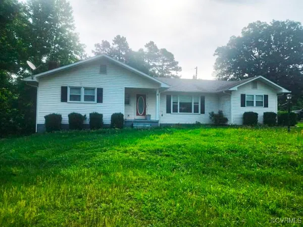 a view of a house with a yard and potted plants