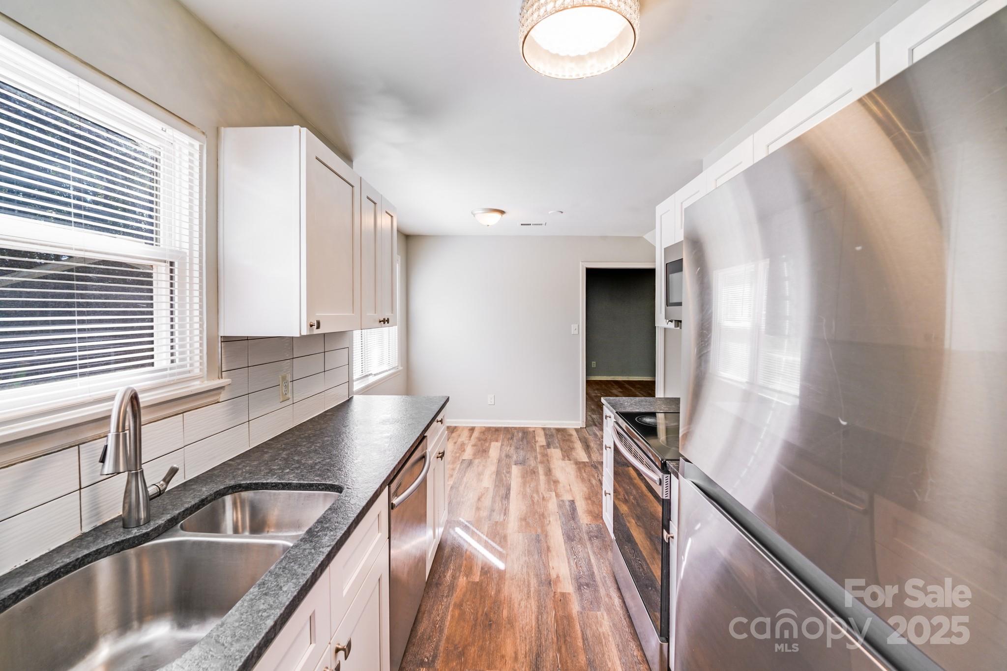 6226 Spanish Oak Road Charlotte, NC 28227 - Photo 12 of 28 a kitchen with a sink and a refrigerator