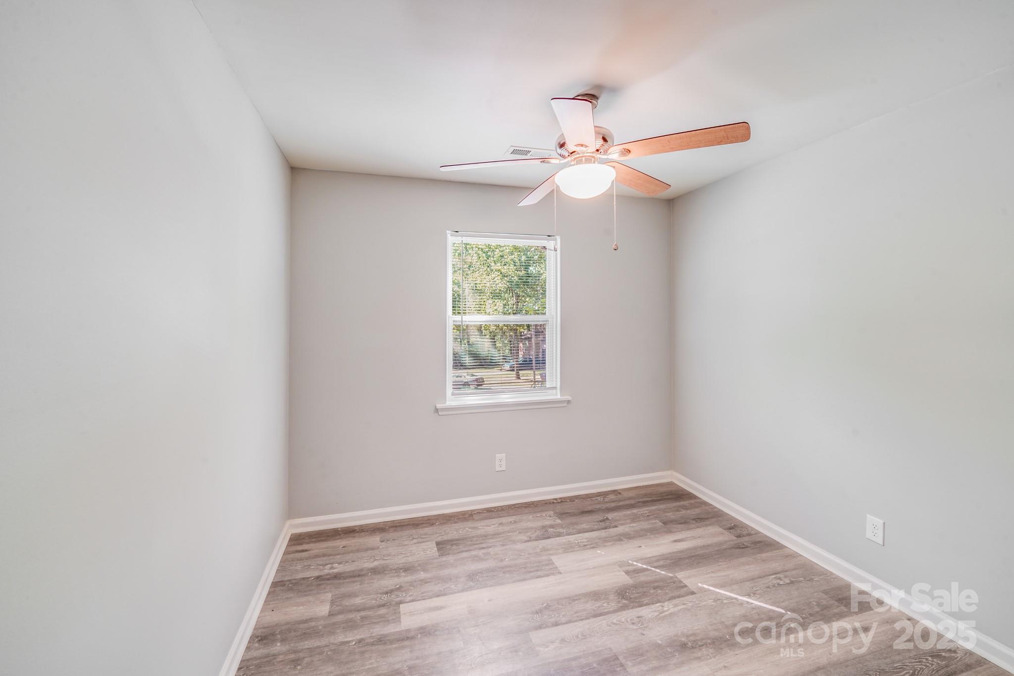 6226 Spanish Oak Road Charlotte, NC 28227 - Photo 16 of 28 an empty room with a window and a ceiling fan