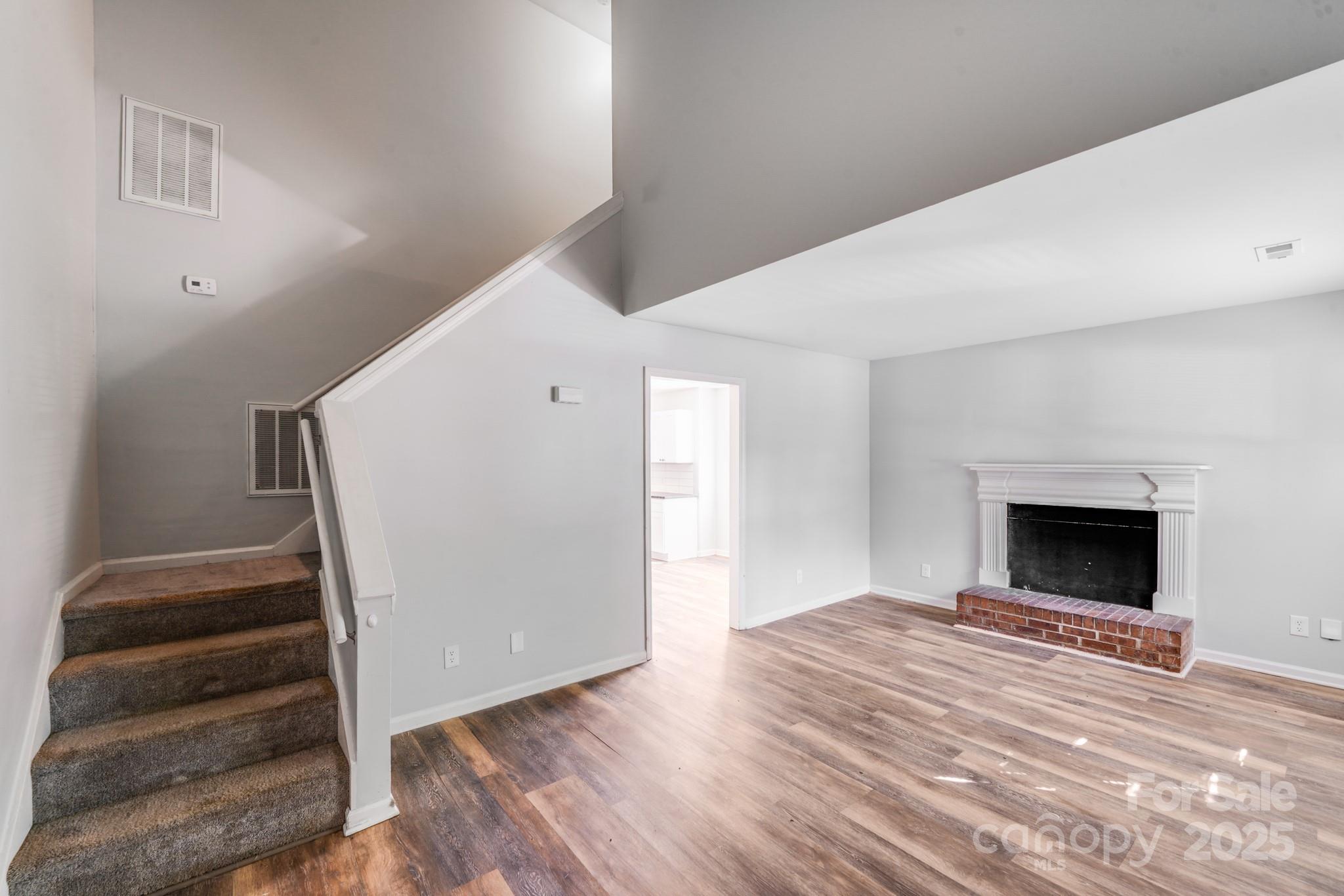 6226 Spanish Oak Road Charlotte, NC 28227 - Photo 2 of 28 a view of empty room with wooden floor and fireplace