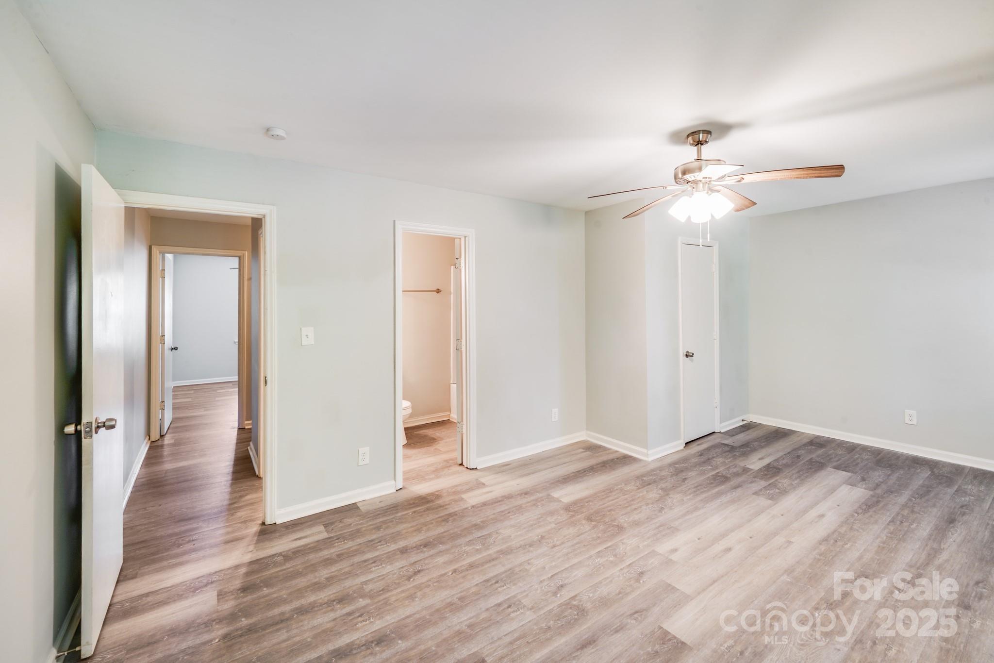 6226 Spanish Oak Road Charlotte, NC 28227 - Photo 22 of 28 an empty room with wooden floor and ceiling fan