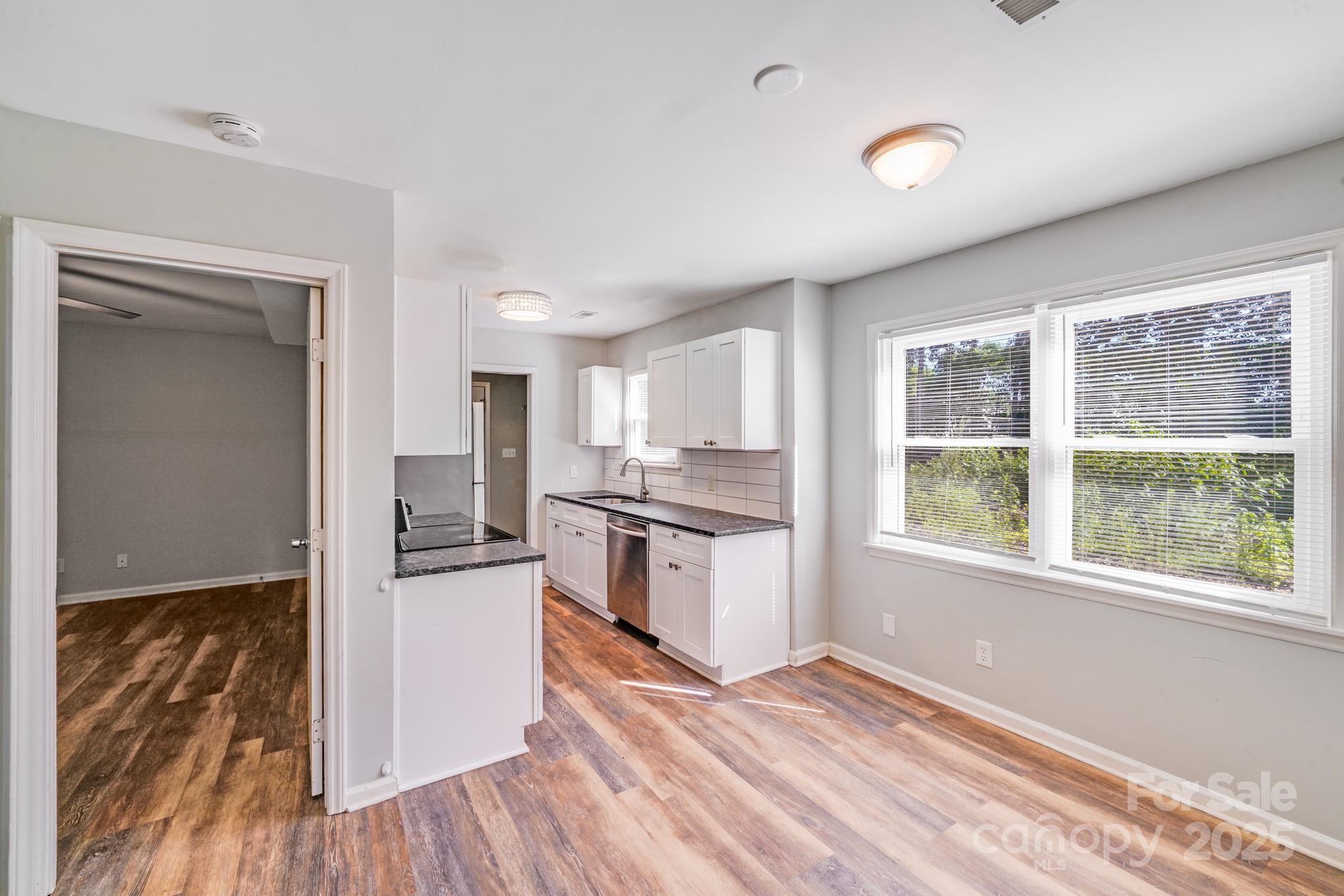 6226 Spanish Oak Road Charlotte, NC 28227 - Photo 3 of 28 a kitchen with granite countertop a refrigerator and wooden floor