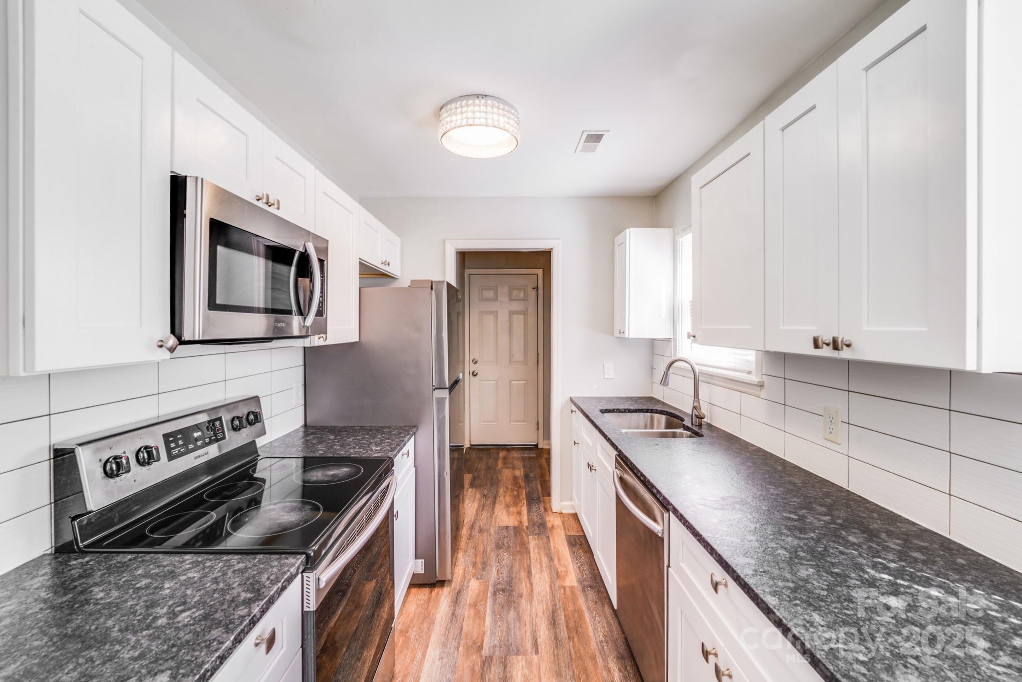6226 Spanish Oak Road Charlotte, NC 28227 - Photo 4 of 28 a kitchen with stainless steel appliances granite countertop a sink stove and refrigerator
