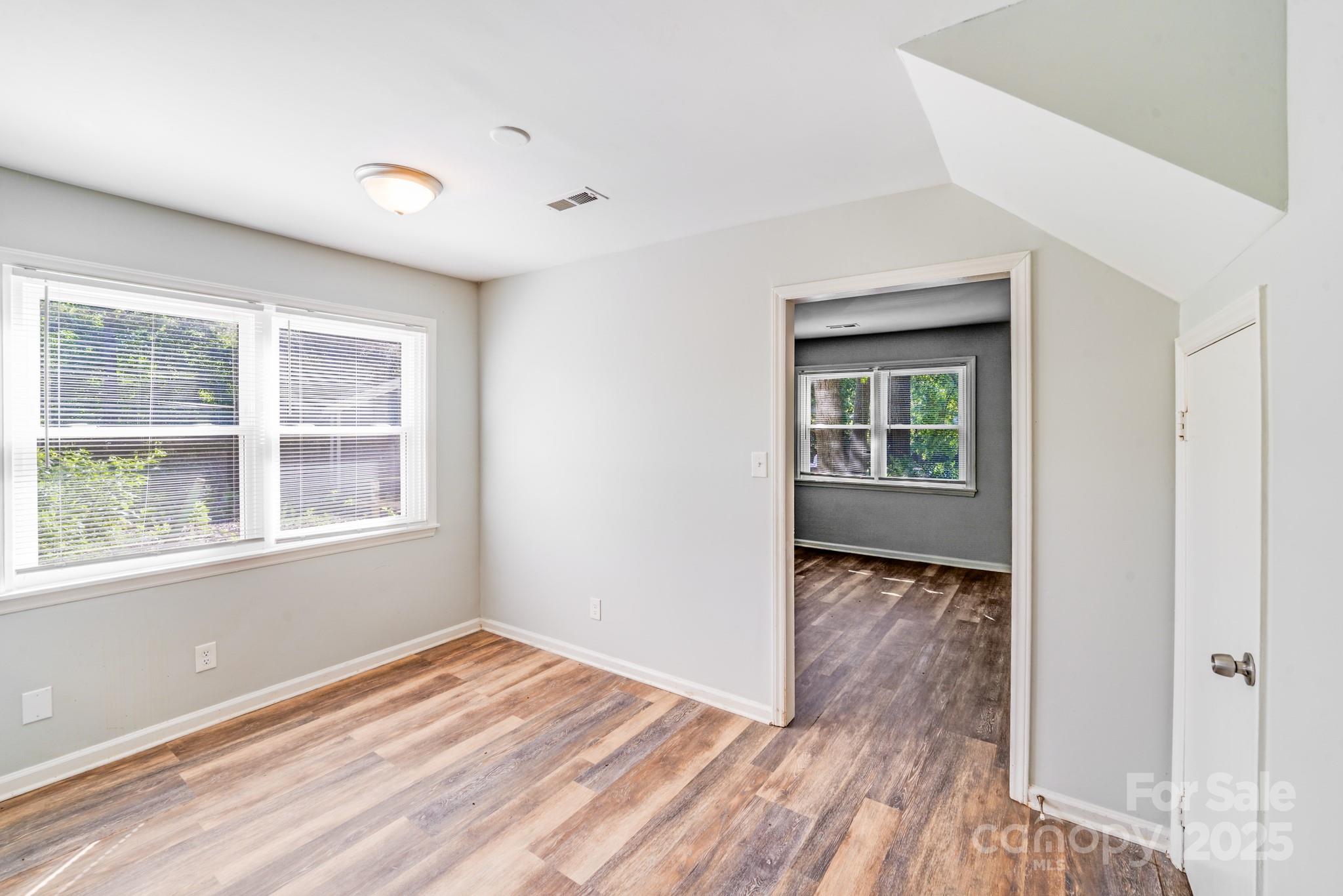 6226 Spanish Oak Road Charlotte, NC 28227 - Photo 5 of 28 an empty room with wooden floor and a window