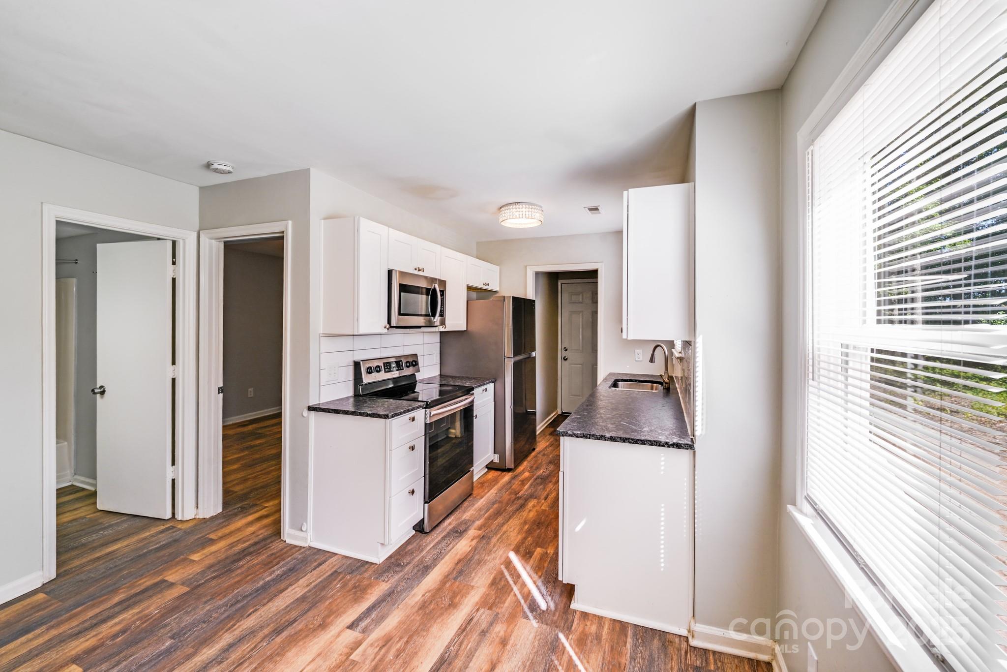 6226 Spanish Oak Road Charlotte, NC 28227 - Photo 10 of 28 a kitchen with a refrigerator and a stove top oven