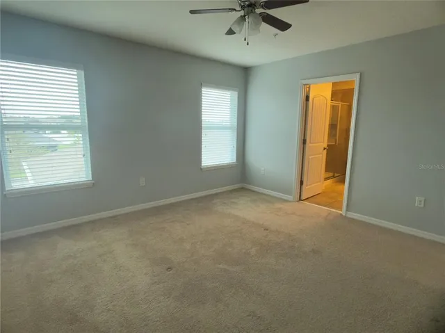 an empty room with a chandelier fan