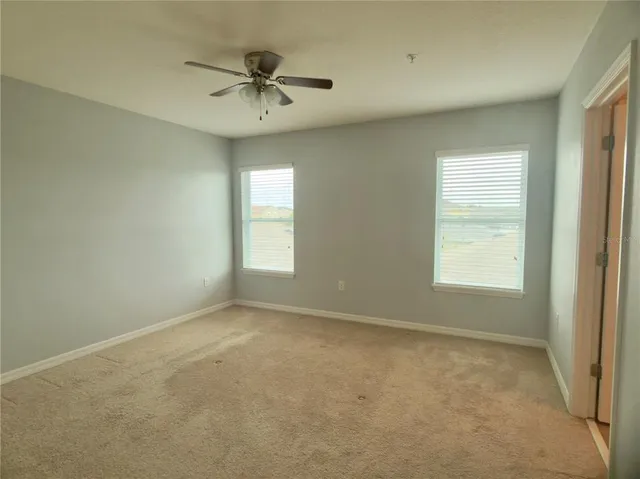 an empty room with closet and a chandelier fan