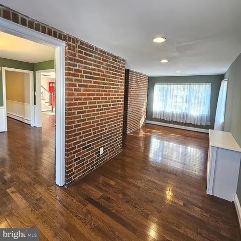a view of a hallway with wooden floor and closet