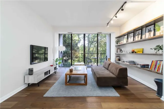 a living room with furniture large window and a flat screen tv