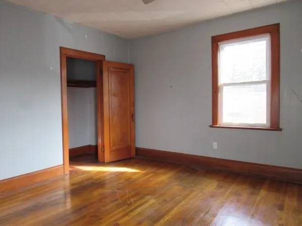 an empty room with windows and closet