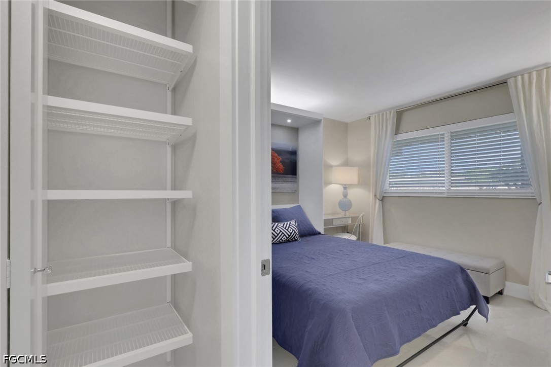 9 High Point Circle North, Unit 101 Naples, FL 34103 - Photo 27 of 49 a bedroom with a bed and lamp