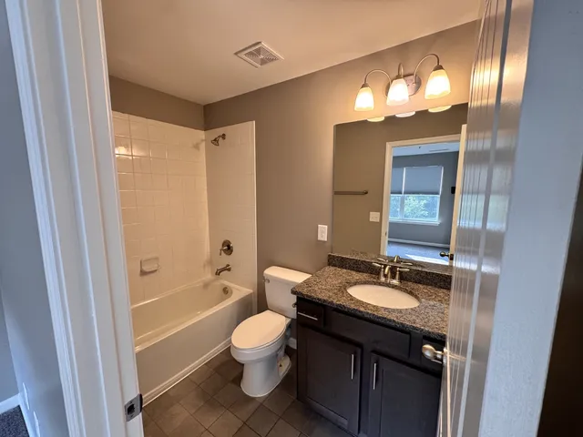 a bathroom with a sink a toilet and a large mirror