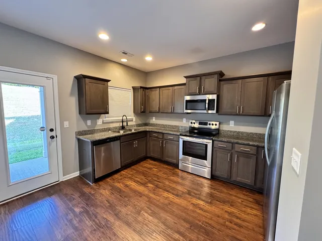 a kitchen with a sink and steel appliances