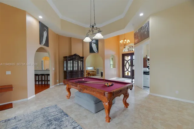 a living room with furniture a chandelier and a flat screen tv