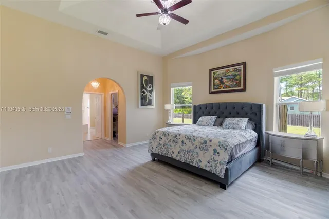 a bedroom with a large bed and a chandelier