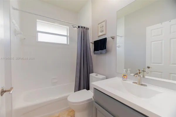 a bathroom with a sink a toilet a mirror and shower