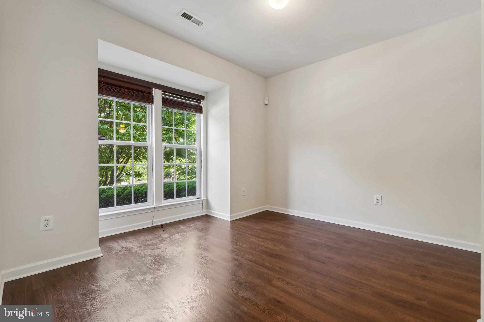 6912 Red Clay Forge, Unit 2 Elkridge, MD 21075 - Photo 23 of 46 a view of an empty room with wooden floor and a window