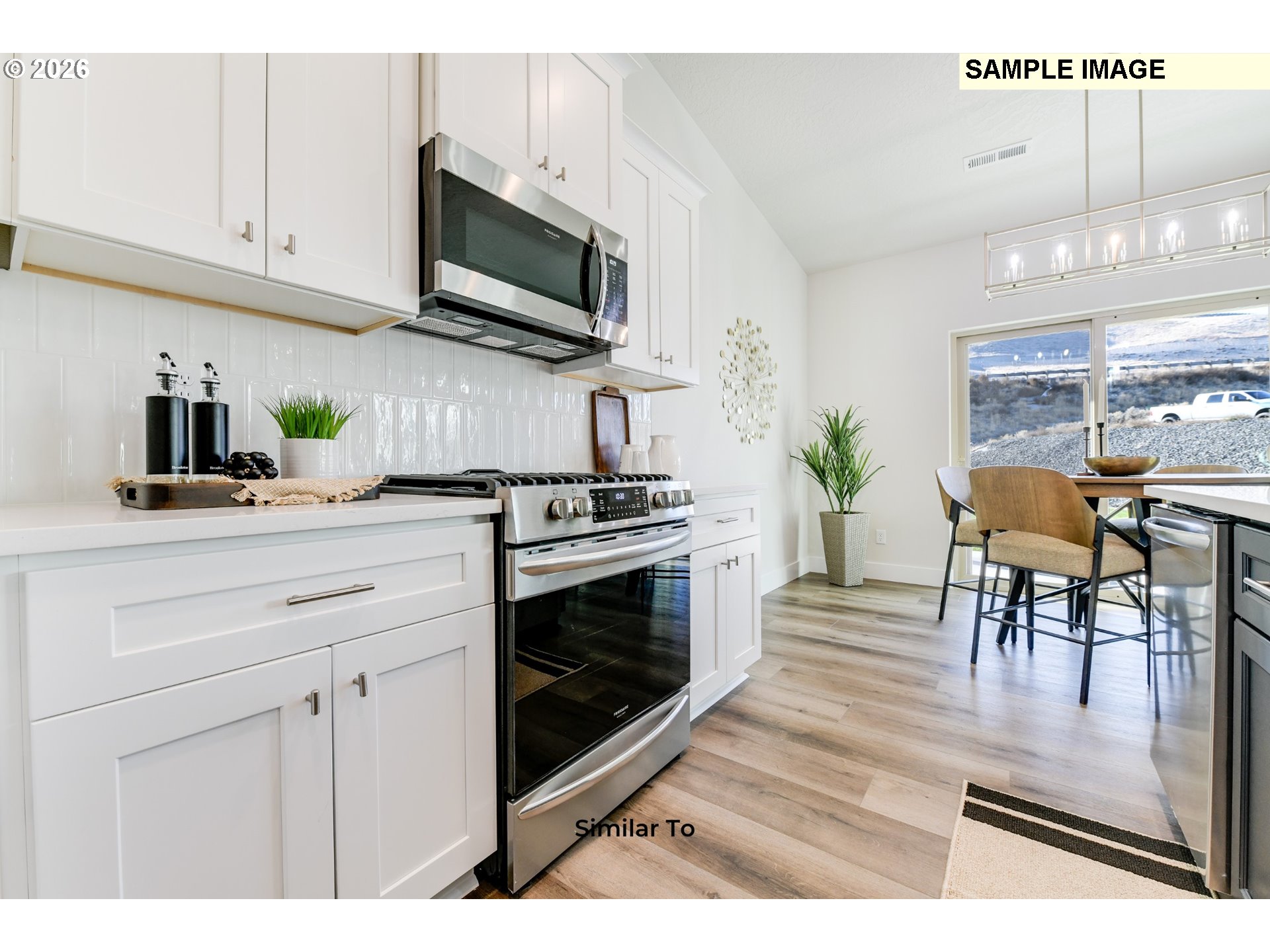215 Southwest Sparrow Street Boardman, OR 97818 - Photo 8 of 28 a kitchen with stainless steel appliances kitchen island granite countertop a stove a sink and a microwave