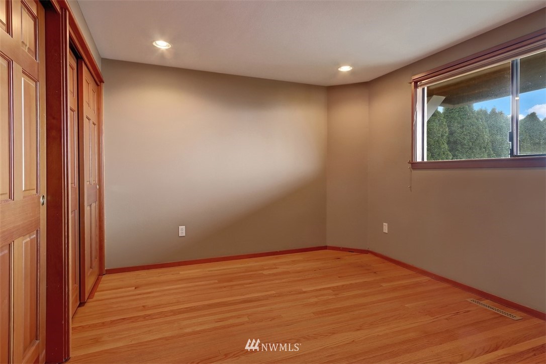 17041 Talbot Road Edmonds, WA 98026 - Photo 15 of 25 an empty room with wooden floor and windows