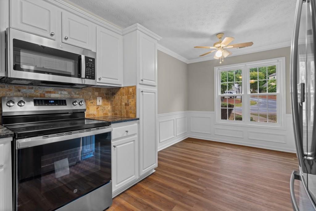 3525 Magnolia Walk Trail Cumming, GA 30040 - Photo 6 of 31 a kitchen with granite countertop wooden cabinets stainless steel appliances and a window