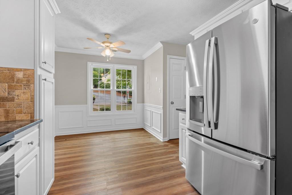 3525 Magnolia Walk Trail Cumming, GA 30040 - Photo 7 of 31 a view of a kitchen with wooden floor and a ceiling fan