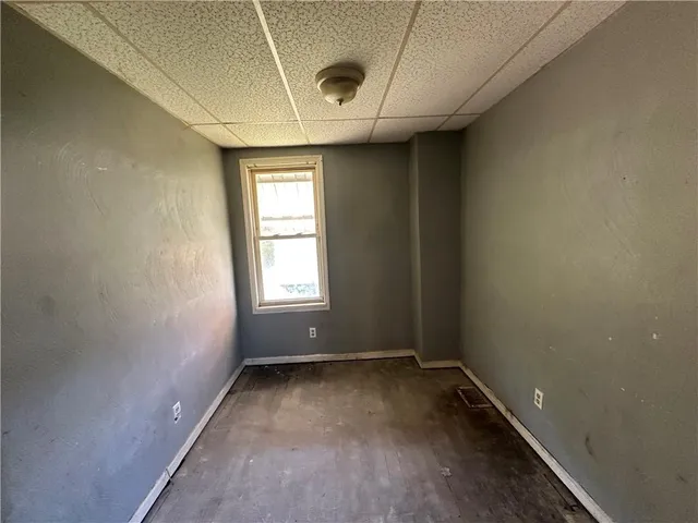 a view of empty room with window and wooden floor