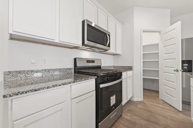 a kitchen with stainless steel appliances granite countertop a stove and a microwave