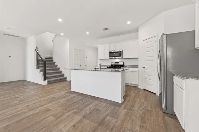 a kitchen with white cabinets and stainless steel appliances