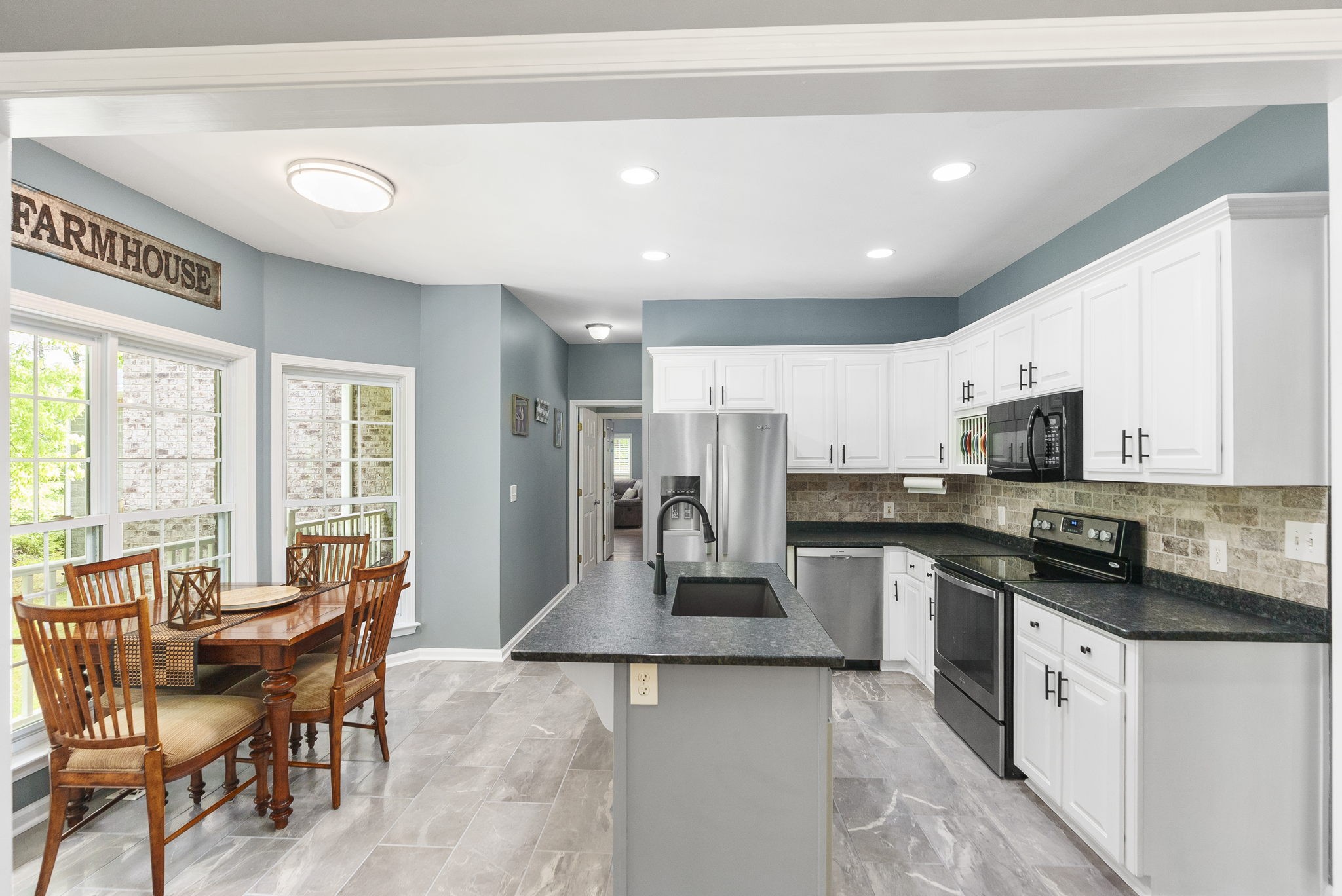 5298 Ridge Road Joelton, TN 37080 - Photo 18 of 46 a kitchen with stainless steel appliances granite countertop a stove top oven a sink dishwasher a dining table and chairs with wooden floor