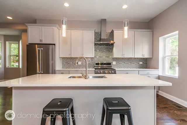 a kitchen with stainless steel appliances a sink stove and refrigerator