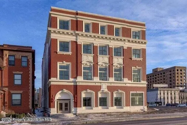 a front view of a brick building with many windows