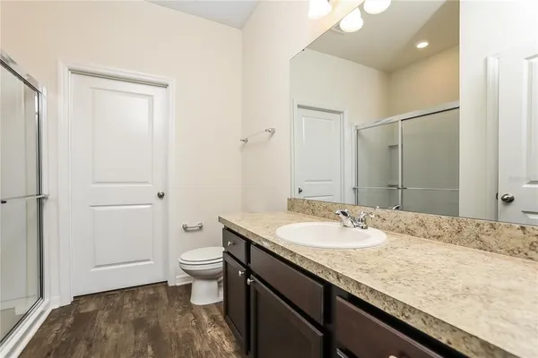 a bathroom with a granite countertop sink a toilet and shower