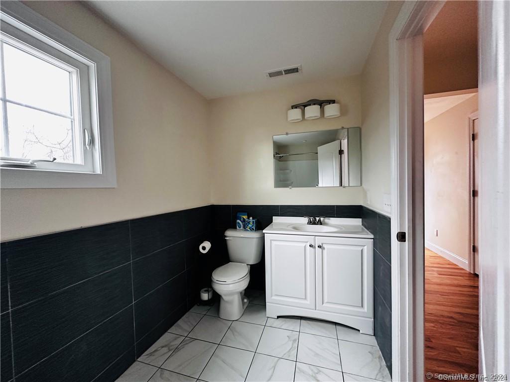 31 Brainerd Road Branford, CT 06405 - Photo 23 of 39 a bathroom with a toilet a sink and mirror
