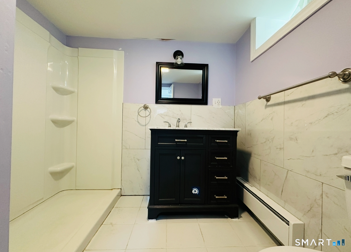 31 Brainerd Road Branford, CT 06405 - Photo 38 of 39 a bathroom with a sink a mirror and a shower